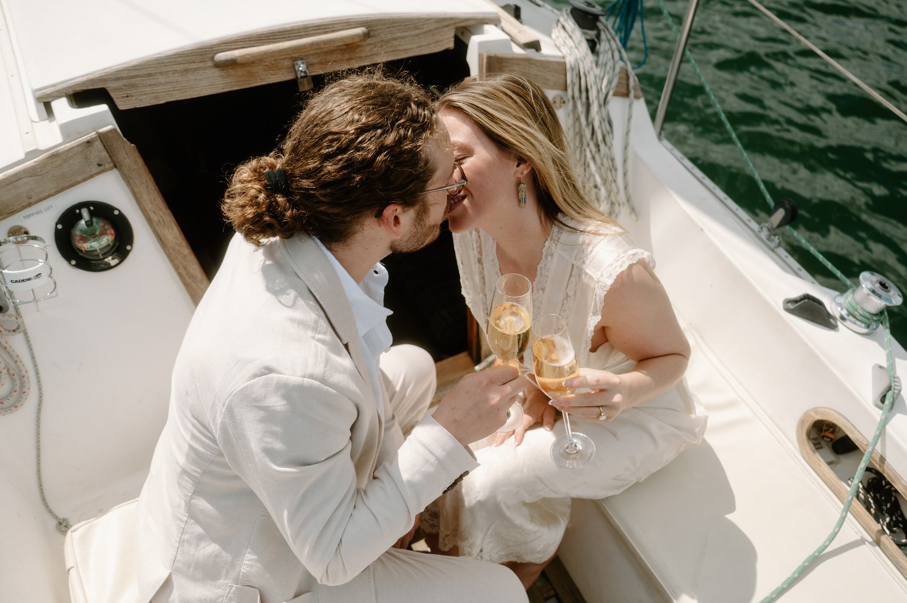 Lauren and Christopher kissing in the sailboat cockpit